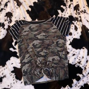 a camouflage and black and white striped shirt